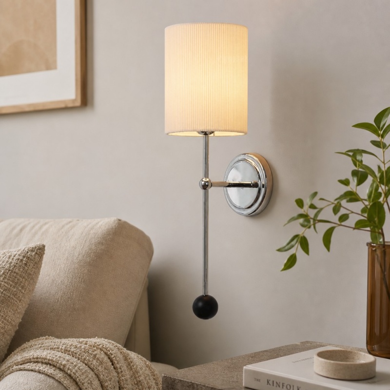 Cumoris wall lamp glowing beside a sofa